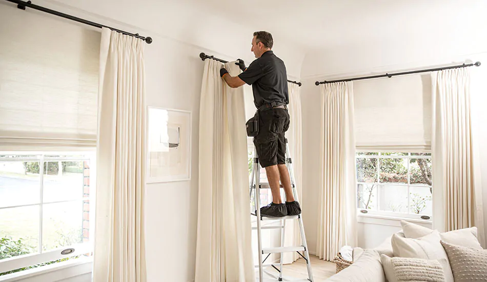 Curtain rod extending several inches past each side of a window frame with drapes stacked open