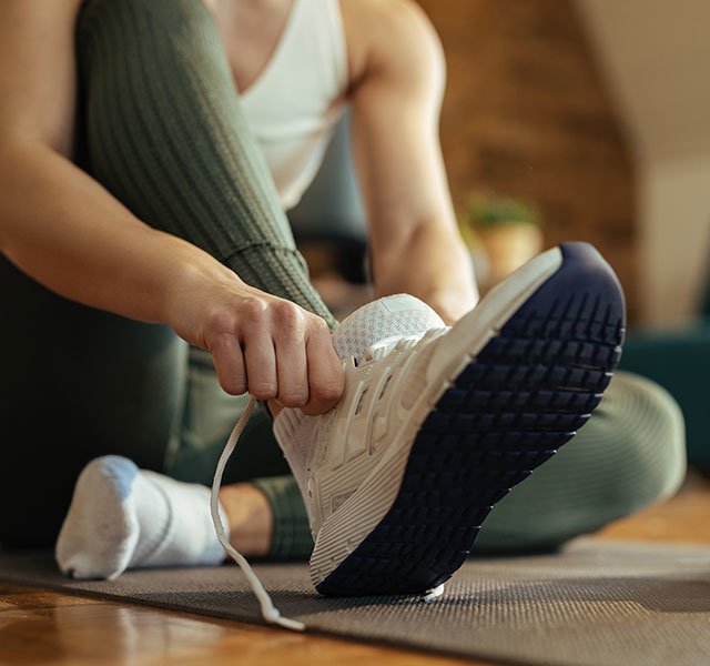 Person wearing shoes inside the house on wooden floor