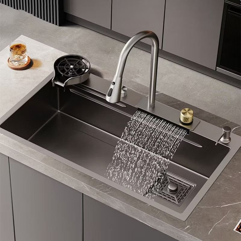 Modern stainless steel undermount kitchen sink installed beneath a quartz countertop